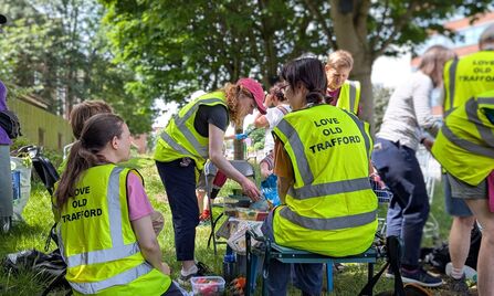 The Love Old Trafford volunteers, sitting around sharing food, enjoying a well-earned break