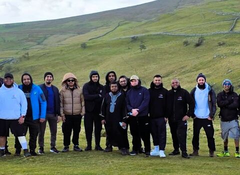 A group of nineteen men out on a walk in the countryside